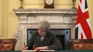 Theresa May en su despacho firmando la carta.