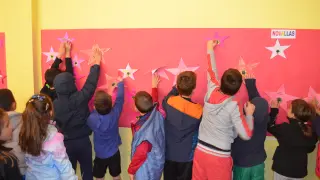 Los alumnos colocan las estrellas de la fama en su mural de cine