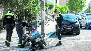 Tres agentes de la Policía Local inspeccionan la motocicleta del accidentado.