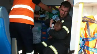Un bombero de la DPZ da el biberón a un bebé que viajaba en un vehículo accidentado el pasado viernes entre Caspe y Maella. La imagen ha sido compartida en Facebook por la DPZ.