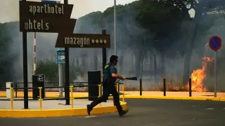 Un guardia civil intenta sofocar el fuego cerca de un bloque de partamentos.