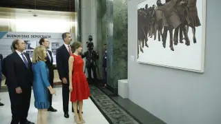 Los Reyes observan el simbólico cuadro 'El abrazo', de Juan Genovés, en la exposición en el Congreso "Habla pueblo, habla"