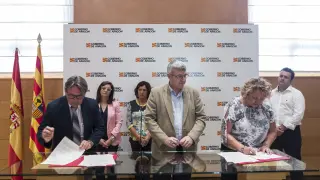 Santiago Cosculluela, presidente de Arade; Joaquín Santos, gerente del IASS, y Pilar Celiméndiz, de Lares, firman el acuerdo.