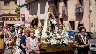 Los vecinos de Garrapinillos desfilan junto a la Virgen del Carmen ayer por las calles del barrio.