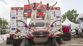 Nasser Al Attiyah celebra su triunfo en la prueba aragonesa junto a su copiloto, Mathieu Baumel, encima de su coche, un Toyota Hilux.