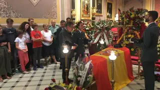 El ministro, en la visita a la capilla ardiente, imponiéndole la condecoración en presencia de la familia del guardia civil fallecido.