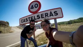 Laura Uranga y Pablo Ferrer junto al cartel de entrada a Castelserás