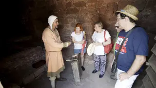 Un recreacionista muestra a los visitantes cómo funcionaba una ceca en el siglo XIII.