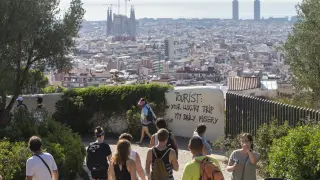 Un grupo de turistas pasea por los alrededores del Parque Guell de Barcelona, donde últimamente ha  aparecido pintadas contrarias al turismo masificado.