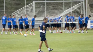 Natxo González, pensativo, con su plantilla al fondo, durante un entrenamiento del Real Zaragoza.