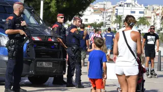 Varios policías armados vigilan ayer en Cambrils ante el paso de los turistas.