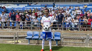 Mikel González posa sonriente con un balón entre sus manos, ayer durante su presentación en el césped de La Romareda.