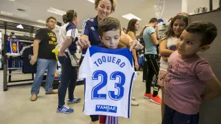 Un pequeño aficionado zaragocista muestra la camiseta de Toquero, ayer en la tienda del club.