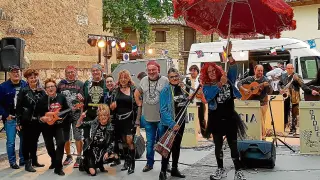 Un grupo de vecinos del municipio disfrazados disfrutando del concierto de la orquesta Palancia.