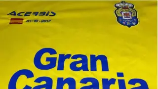 Detalle del frontal de la camiseta especial de la UD Las Palmas para jugar esta tarde del domingo en el Camp Nou ante el FC Barcelona: la novedad es la bandera de España bordada, con la fecha del 1-O.