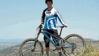 El joven Gabi Torralba posa con su bicicleta y su equipación habitual.