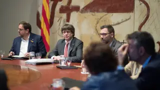 El presidente de la Generalitat, Carles Puigdemont (d) y el vicepresidente, Oriol Junqueras (i), durante la reunión semanal del gobierno catalán, a dos días de que el Parlament se reúna para acordar una respuesta a la aplicación del artículo 155 de la Constitución, asunto que analizarán en comisión los ocho senadores designados por la cámara catalana.