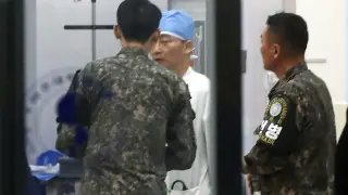 Militares surcoreanos hablan con un médico en un hospital