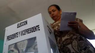Una mujer echa su voto en una de las urnas