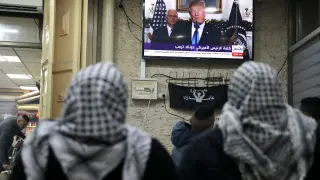 Dos palestinas ven por la televisión el anuncio de Trump.