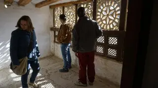 Un grupo de turistas visita la celda de la superiora del convento de Mirambel ante el mirador con celosía