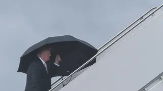 Trump, en las escaleras del Air Force One, con el paraguas que no compartió.