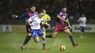Brezancic y Aguilera pelean un balón con Xumetra en el que fue la última derrota de la SD Huesca en su estadio.