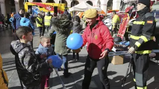 Una componente de la UME regala globos a dos niños en la exposición por el Día Europeo del 112.