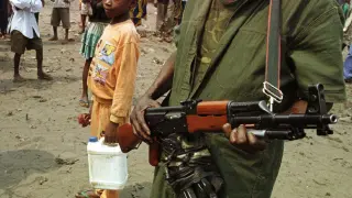 Un niño observa a un soldado en el Congo.