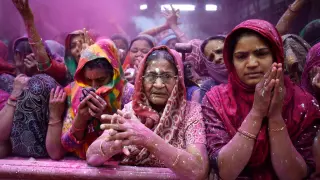 Mujeres rezan dentro de un centro durante la celebración Holi