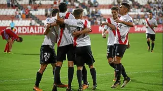 Los futbolistas del Sevilla Atlético celebran uno de los dos goles que anotaron al Real Zaragoza en la primera vuelta en campo andaluz. Carlos Fernández (autor del doblete) y Pozo, ambos de espaldas, estarán ausentes en La Romareda por el 'virus FIFA'.
