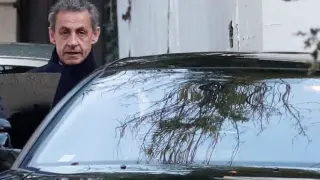El presidente francés Nicolas Sarkozy saliendo de su domicilio y entrando a un coche.