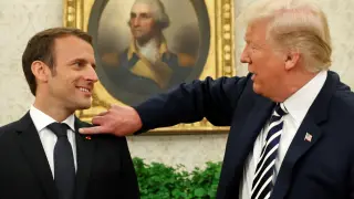 Momento en el que el presidente estadounidense le quita la caspa de la chaqueta a Emmanuel Macron.