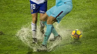 Imagen del partido Real Zaragoza-Barcelona B, con el balón y los jugadores atascados en el agua y el barro en la lluviosa noche de enero... en la que el equipo aragonés también se obturó peligrosamente.