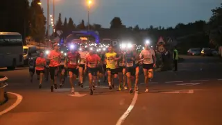Participantes en la carrera nocturna toman la salida junto al Palacio de los Deportes de Huesca.