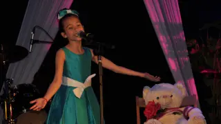 Melani, en el escenario, durante su actuación en Alagón, con su inseparable 'Abracitos'.