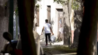 Un joven, ayer, sacando una bolsa de basura de la vivienda en la que vivía el fallecido.