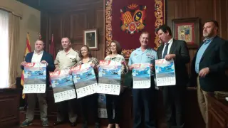 Representantes del Gobierno de Aragón, Ayuntamiento y Ejército con los carteles de la jornada.