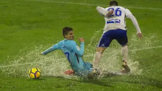Raúl Guti pelea un balón con Ruiz de Galarreta bajo la lluvia, en el partido de ida en La Romareda