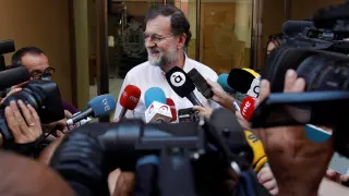 Rajoy atendiendo a los medios antes de entrar a trabajar.