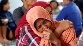 Una mujer llora por su hija, una de las desaparecidas en el naufragio