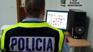 Un agente analiza fotos en un ordenador, en una operación contra la pornografía infantil.