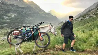 Gabriel Torralba, porteando su bicicleta con uno de los animales de Trekking Mule