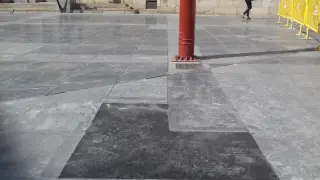 En la plaza de San Bruno se están cambiando algunas baldosas de piedra por una mezcla de cemento y grava.