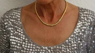 Imagen de una señora con una cadena de oro.