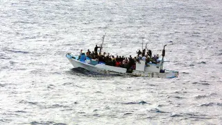 Fotografía de un barco con personas en el mar.