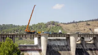 El accidente se ha producido en la presa de La Tranquera, cuando se descargaba una máquina que transportaba el camión.