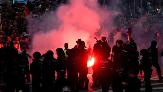 Manifestantes de derecha prenden bengalas mientras enfrentan a la policía antidisturbios en Chemnitz (Alemania).