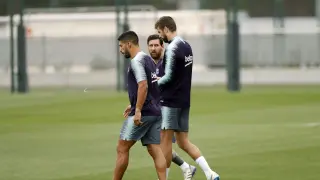 Leo Messi dialoga con Piqué, en presencia de Luis Suárez, durante el entrenamiento que el Barcelona ha completado este sábado.