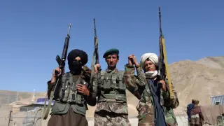Fotografía de archivo que muestra a dos talibanes mientras posan junto a un soldado del Ejército afgano